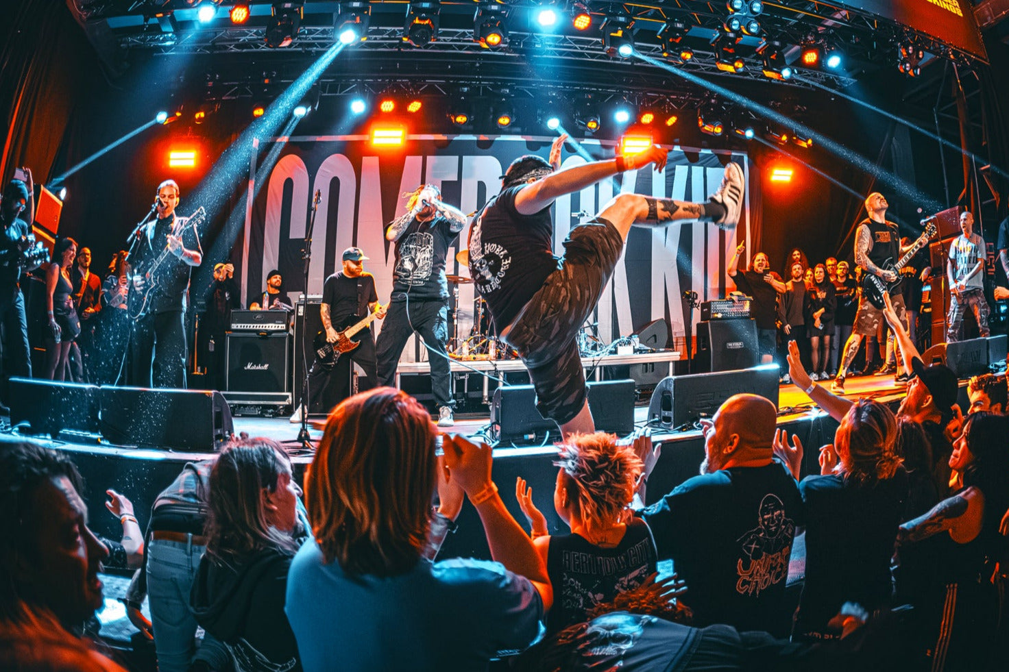 Live concert with band performing on stage and audience enjoying the show.